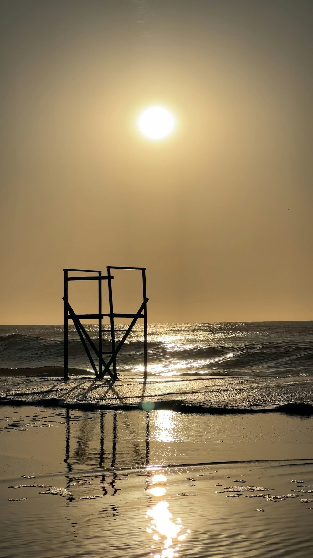 太陽がビーチの水面に沈んでいる