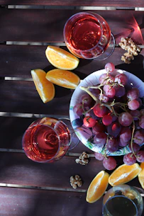 a bowl of grapes and orange slices on a table