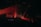 Red laser lights create dynamic lines across a dark club setting, illuminating a crowd of people. The atmosphere is energetic and vibrant with various angles of beams cutting through the dimly lit room.