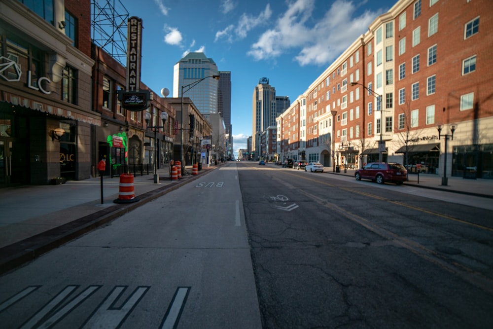 a city street lined with tall buildings under a blue sky