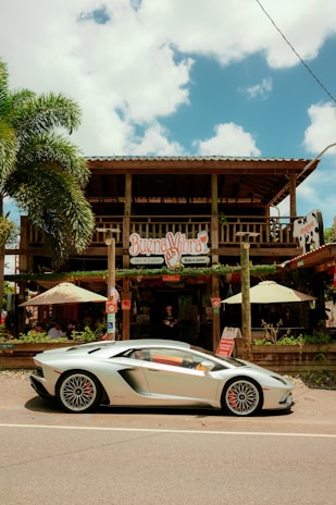 A sleek rental car parked by a sunny Puerto Plata beach with palm trees swaying.