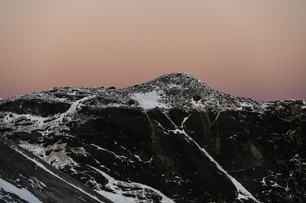 a snow covered mountain with a pink sky in the background