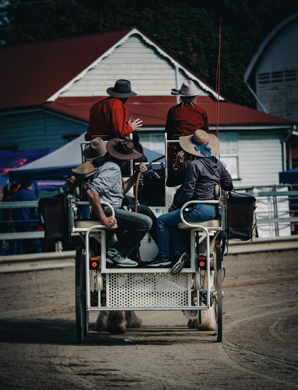 a group of men riding on the back of a horse drawn carriage
