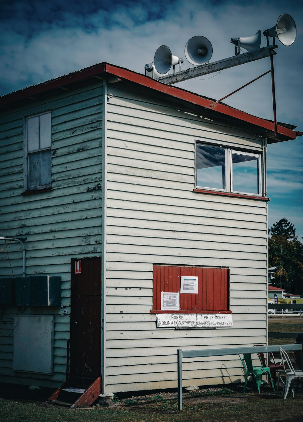 un edificio blanco con un techo rojo y dos antenas parabólicas en la parte superior