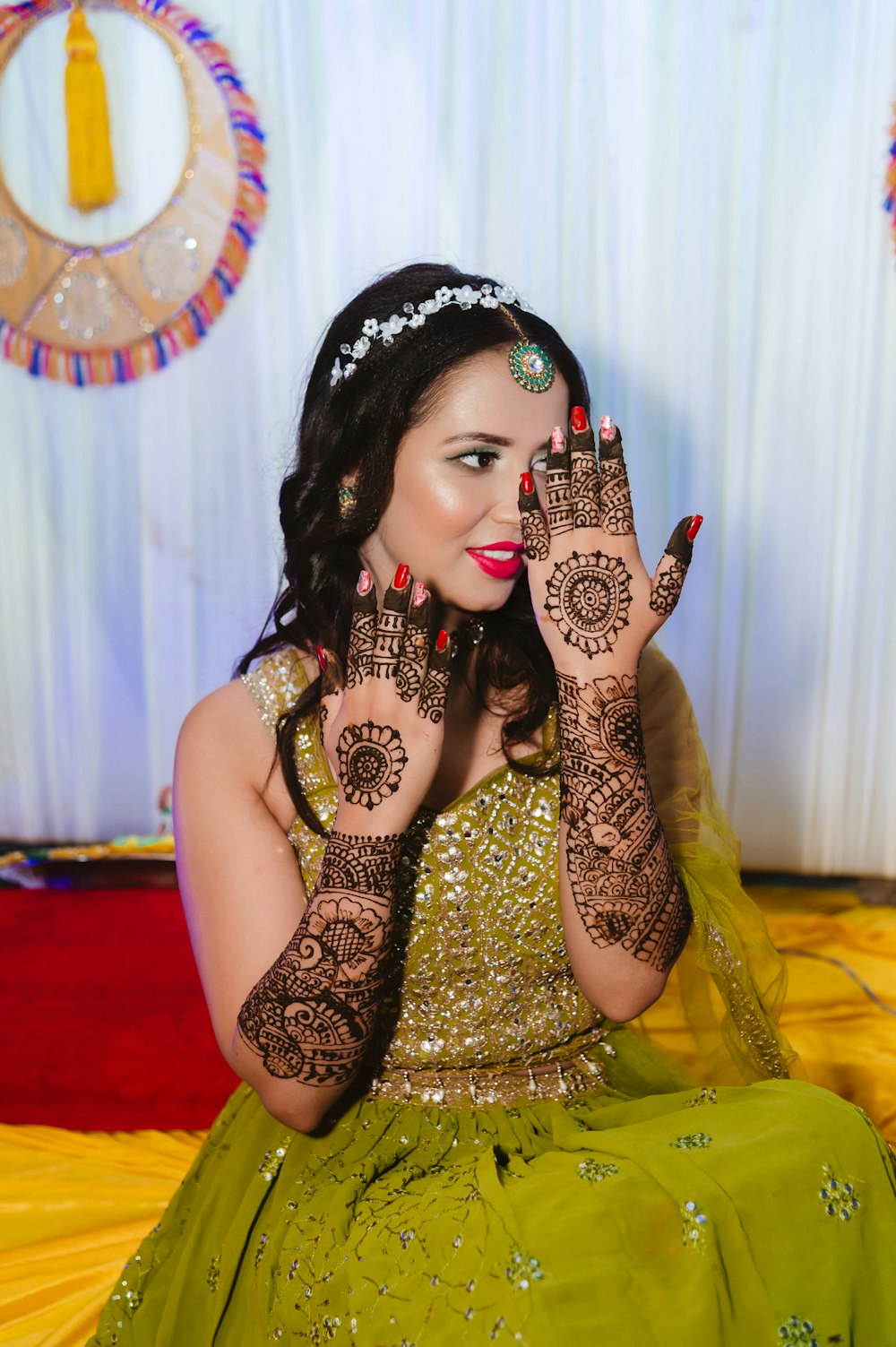 a woman in a green dress holding her hands up to her face