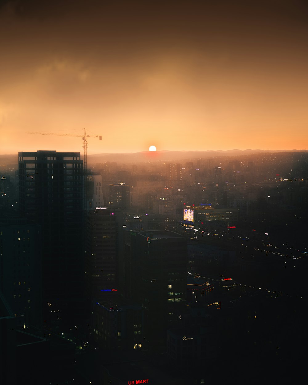 the sun is setting over a city with tall buildings