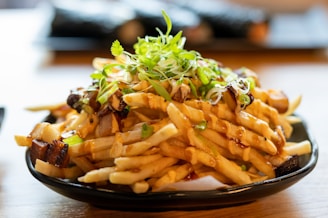 a plate of french fries with sauce and sprouts