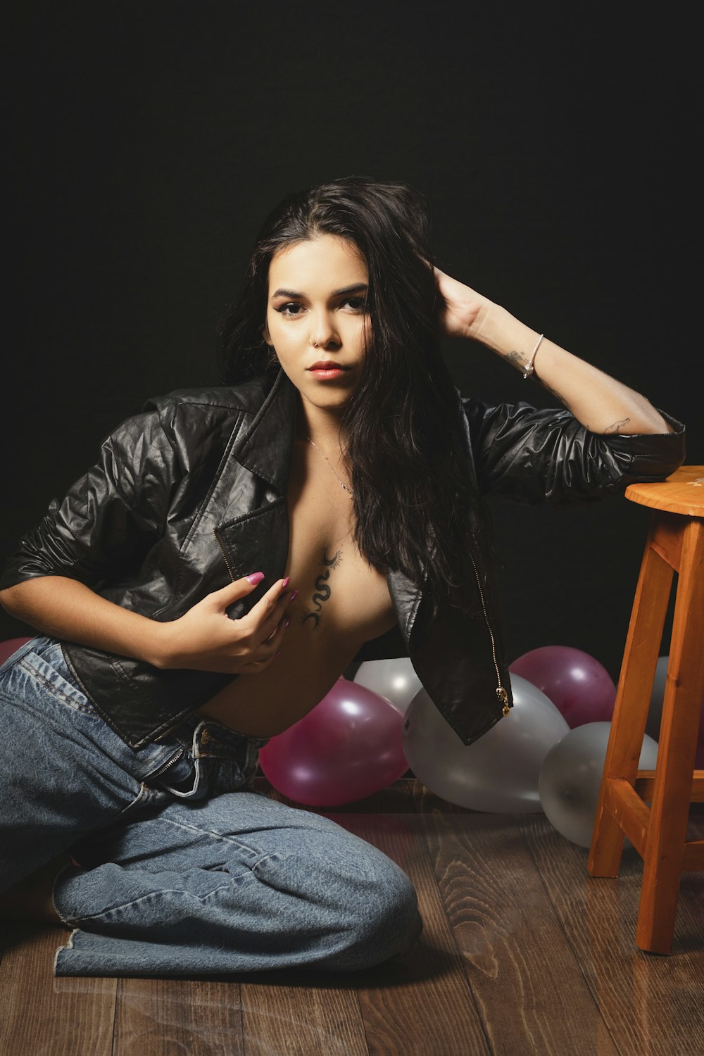 a woman sitting on the floor next to balloons