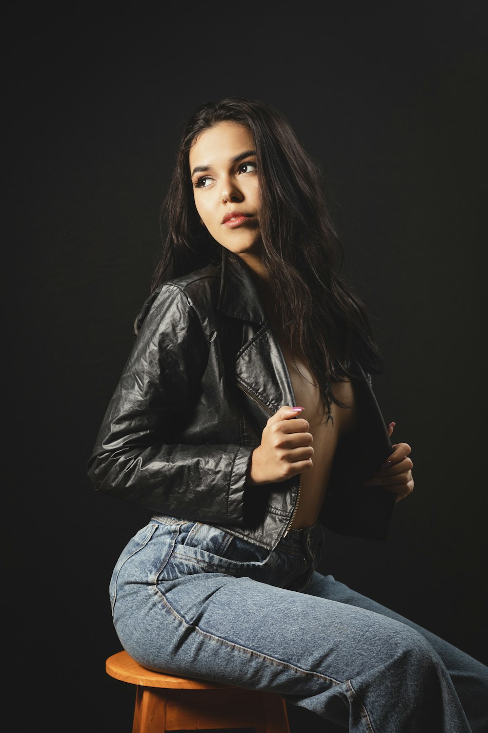 a woman sitting on top of a wooden stool