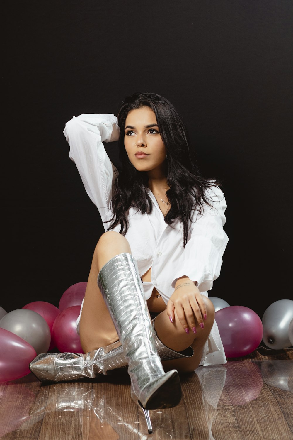 a woman sitting on the floor with a pair of boots