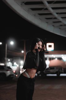 Evening shot of a model wearing layered Lumina Apparel pieces illuminated by city lights