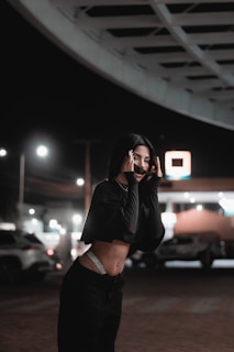 Evening shot of a model in Lumina Apparel reflective gear, illuminated by city lights and passing cars.
