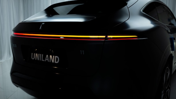 Close-up image of a sleek black rastrea vehicle tracking device emitting blue neon light