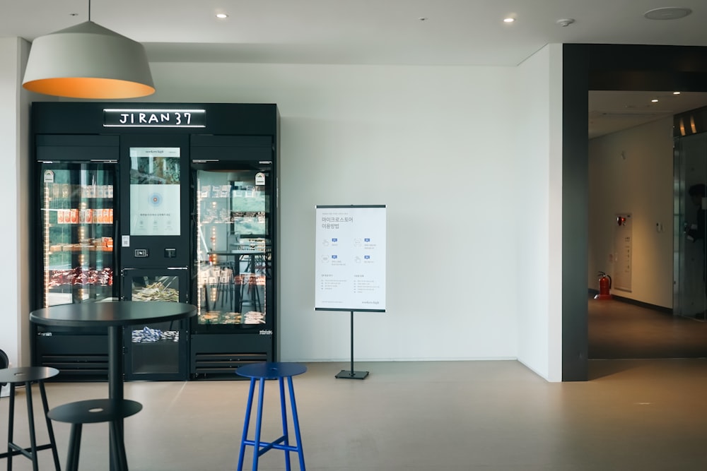 a room with a table, stools, and a display case