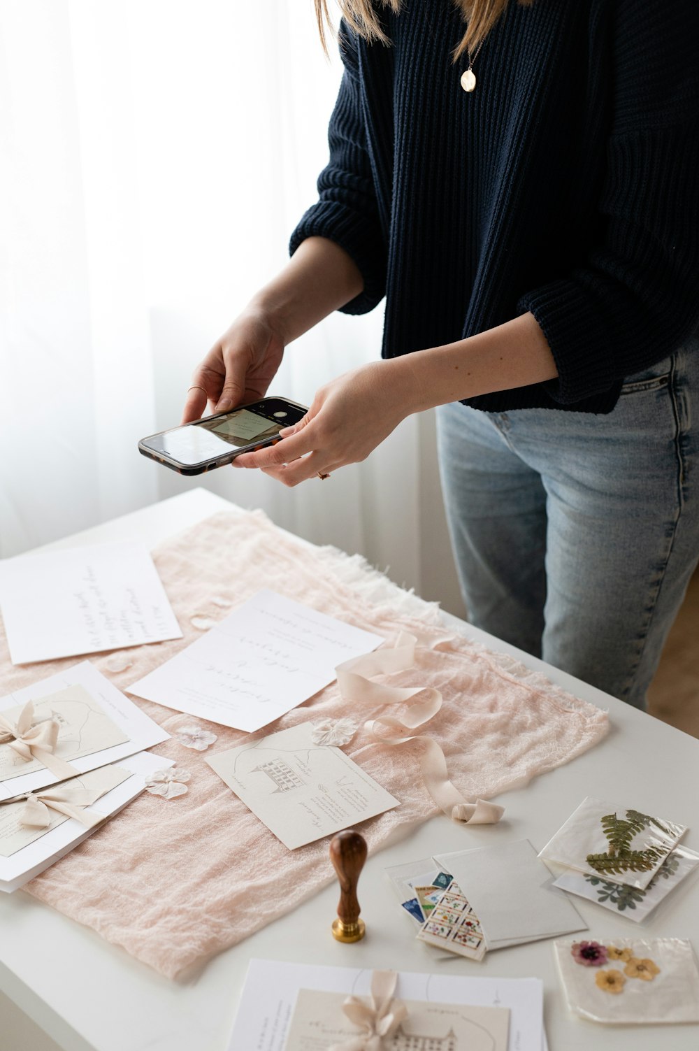 a woman holding a cell phone over a table