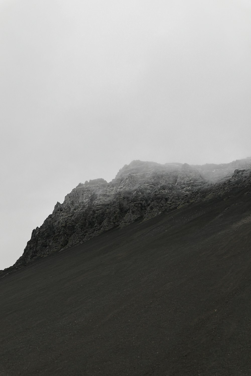 a black and white photo of a mountain covered in snow