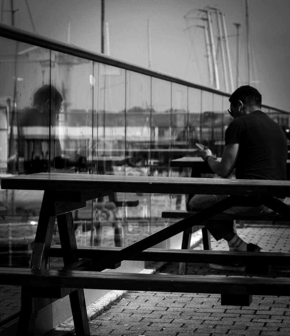 a man sitting on a bench looking at his cell phone