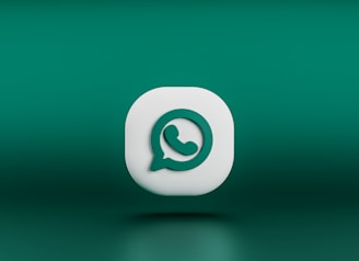 A three-dimensional icon resembling the logo of a chat application, featuring a white speech bubble with a green telephone handle inside. The icon is set against a gradient green background and appears to be floating.