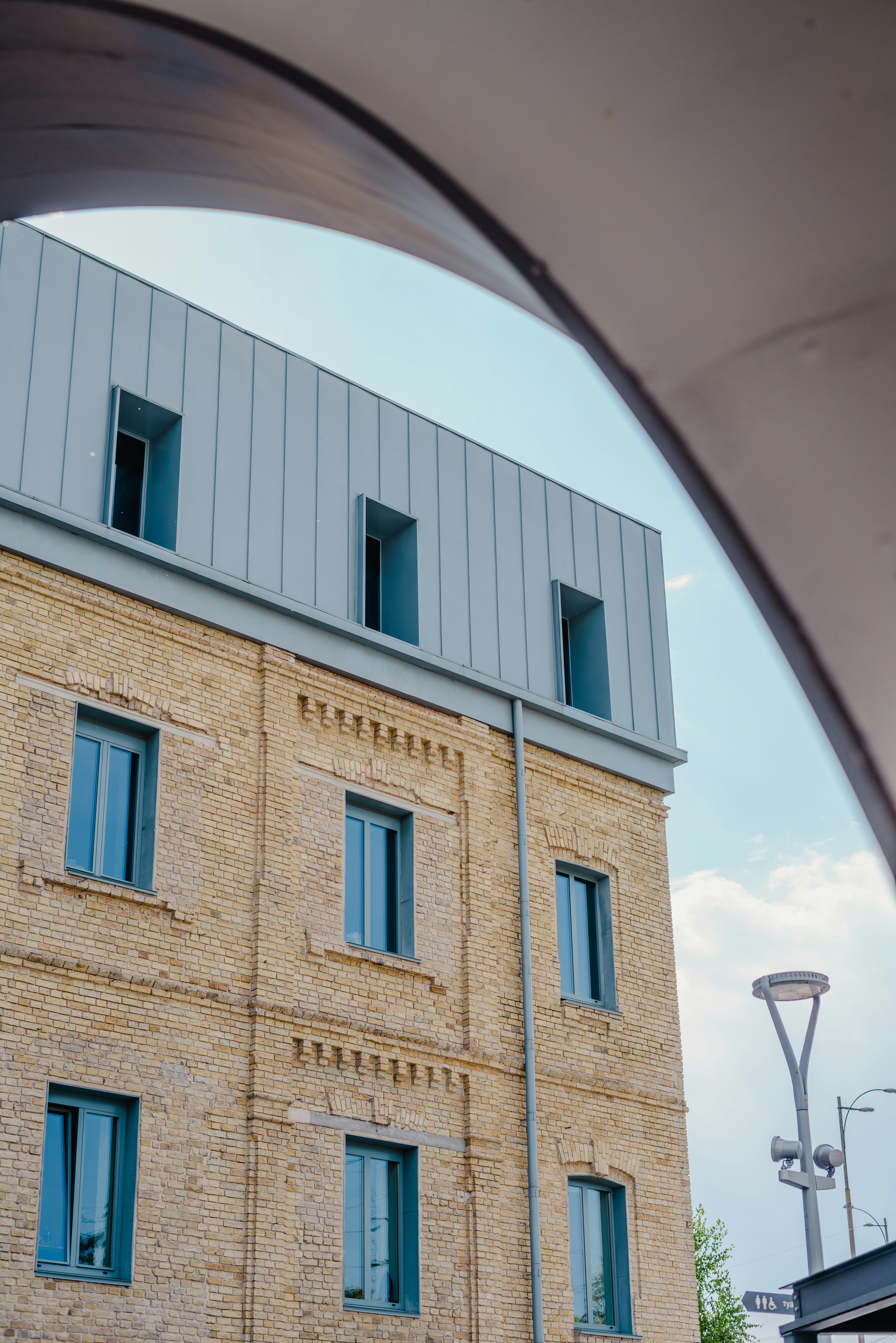 A tall brick building with blue windows under a blue sky photo – Free ...