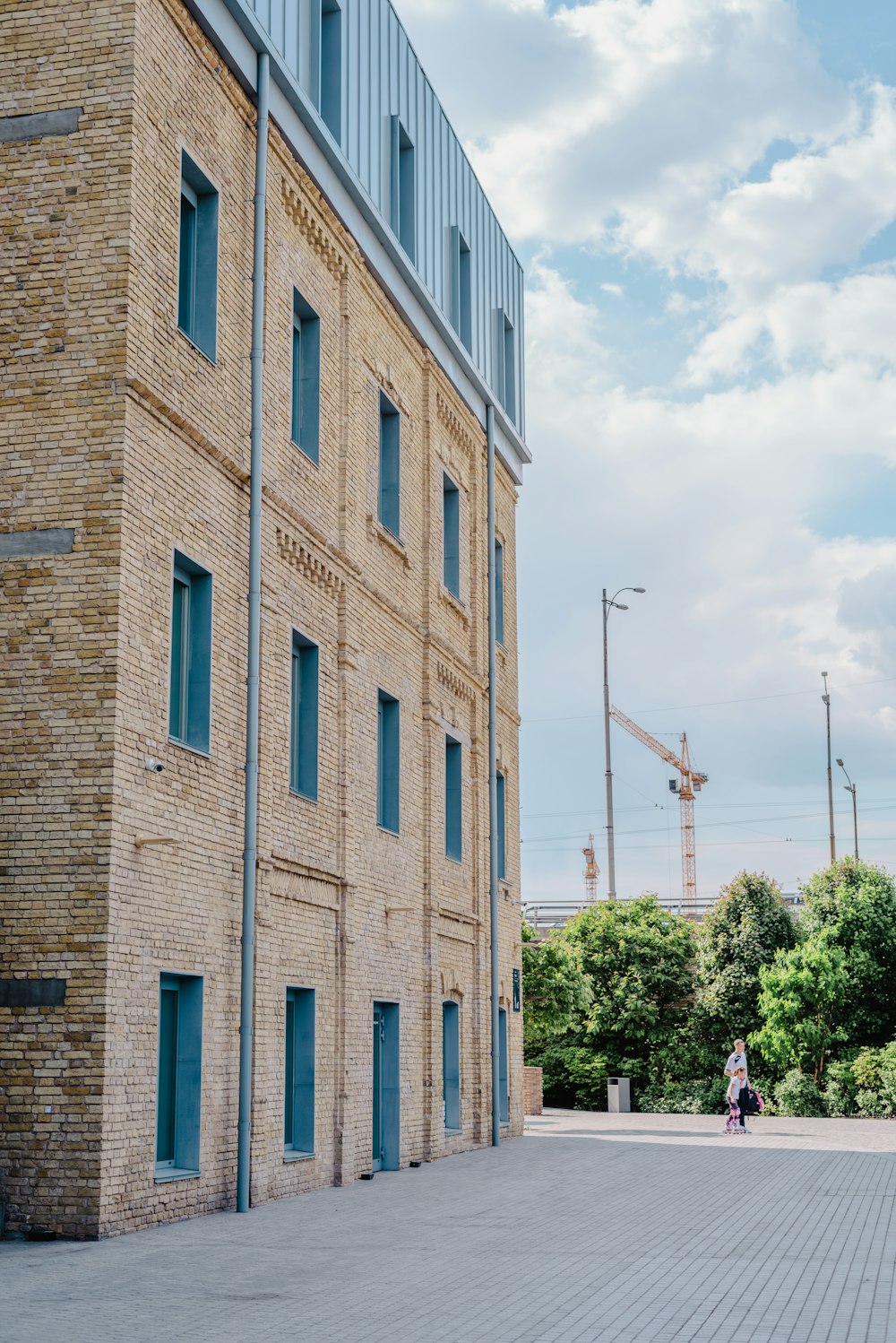 a brick building with blue shutters and a person walking in front of it