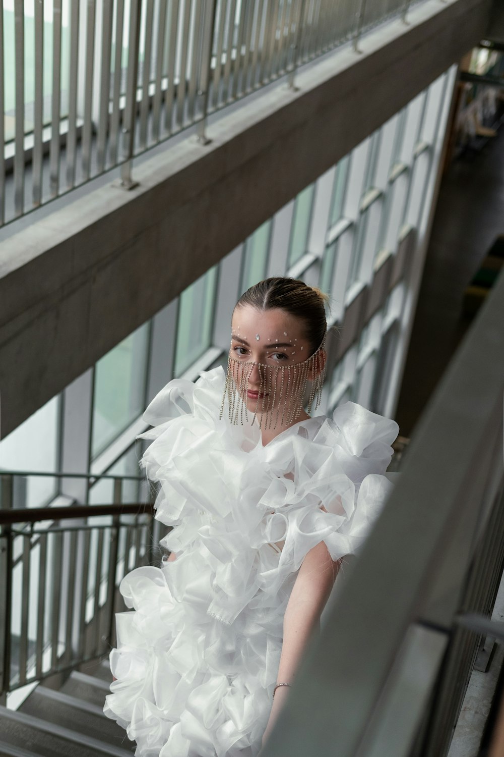 a woman in a white dress walking down a flight of stairs