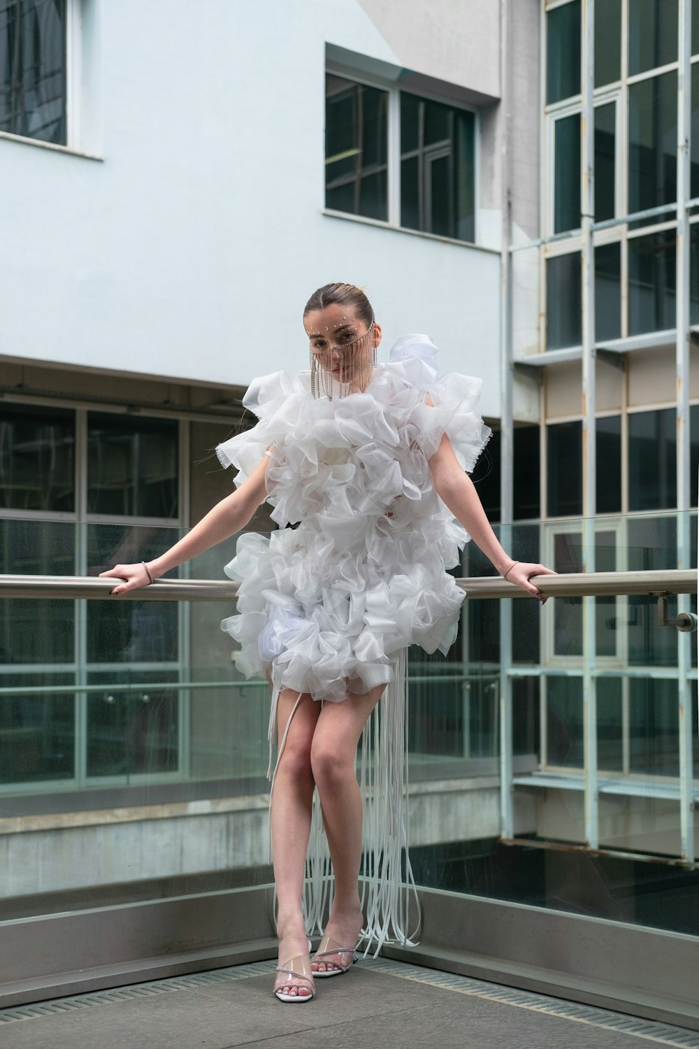 a woman in a white dress standing on a balcony