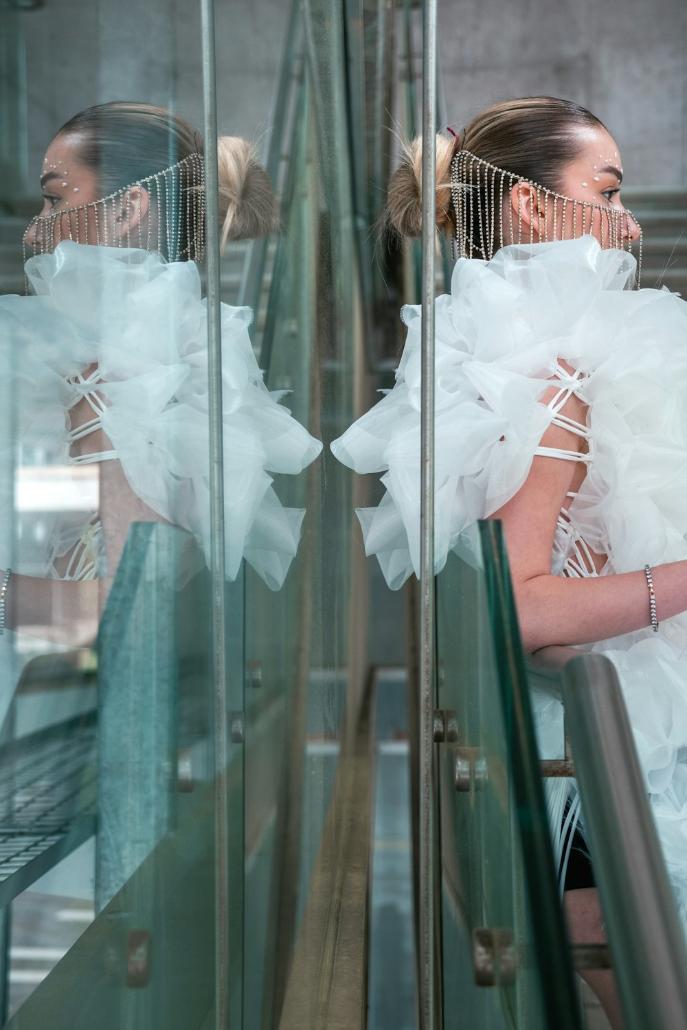 a woman in a white dress with a bird cage on her head