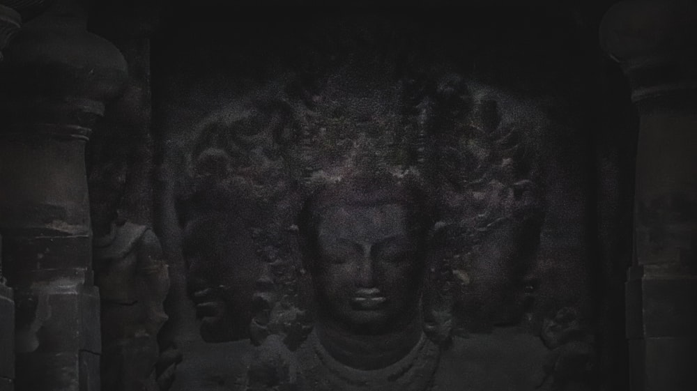 a black and white photo of a buddha head