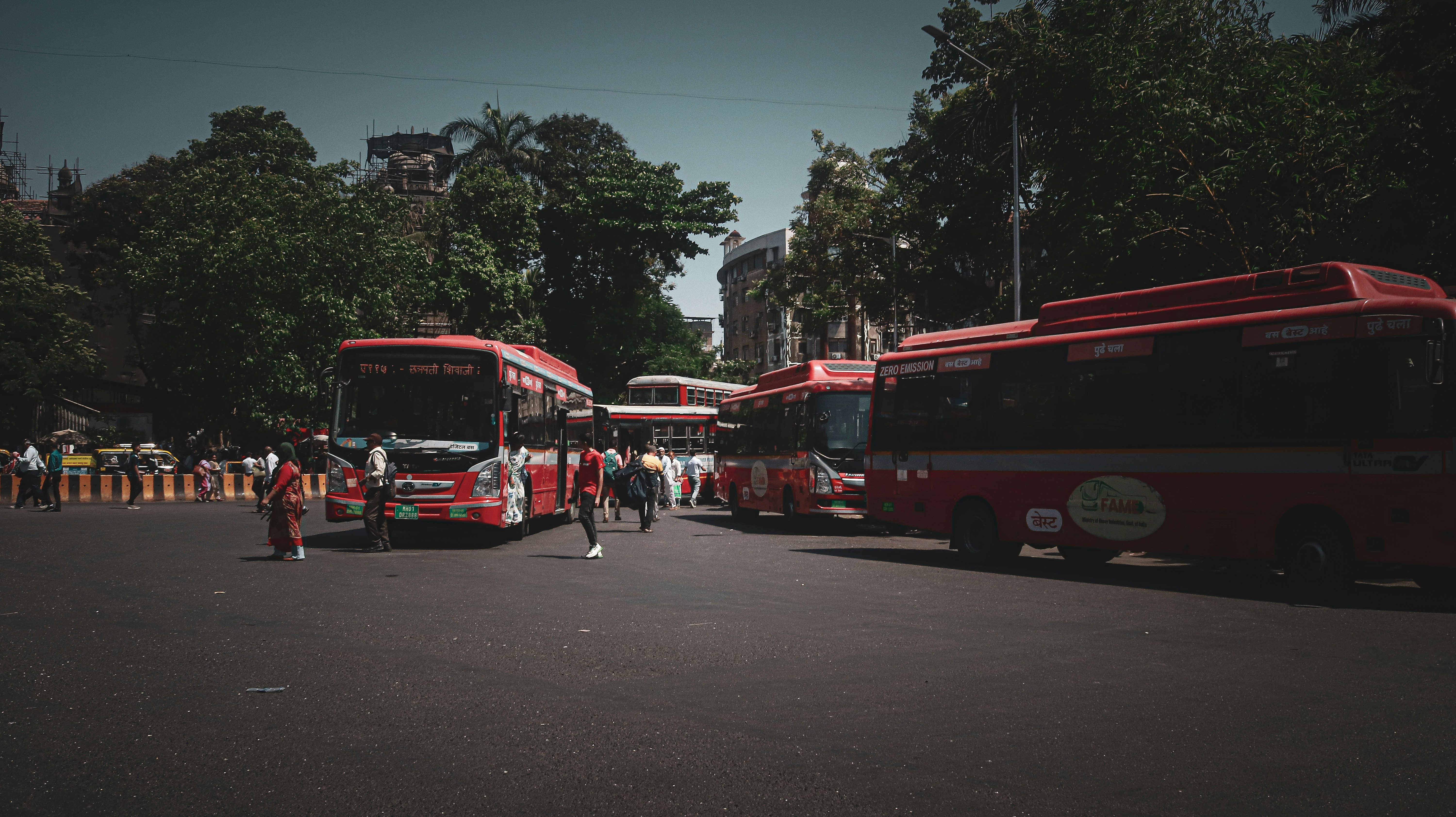 a group of red buses parked next to each other