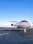 A private jet ready for takeoff on a pristine runway with a clear blue sky.