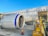 A large airplane on the tarmac, with a close-up view of its engine and baggage being loaded onto the aircraft. The airplane has a Scandinavian airline logo, and the sky is clear and blue.