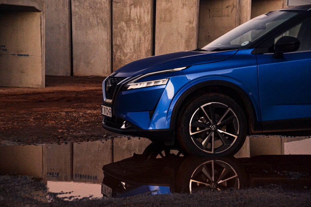 Un SUV azul estacionado frente a un edificio