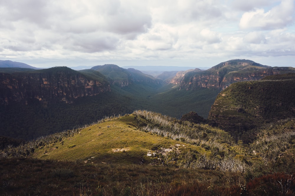 uma vista de um vale com montanhas ao fundo