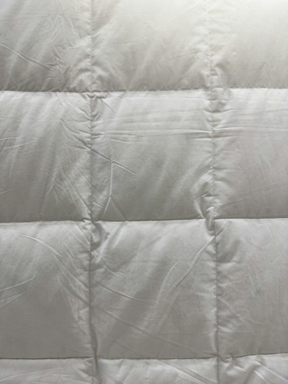 a close up of a bed with a white comforter