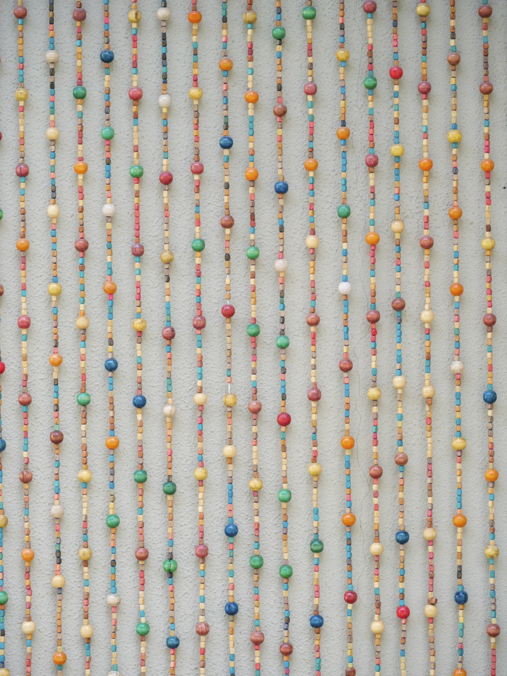 a bunch of beads are hanging on a wall