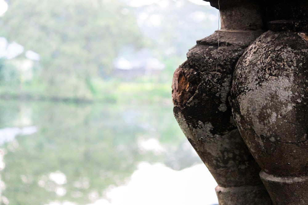 a couple of vases sitting next to a body of water