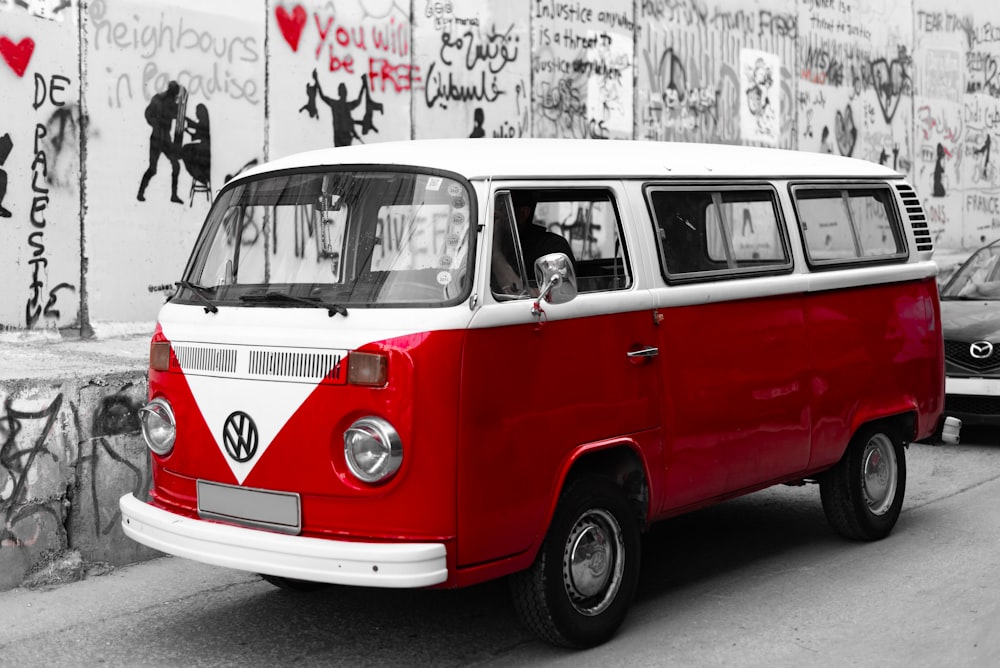 a red and white van parked next to a wall