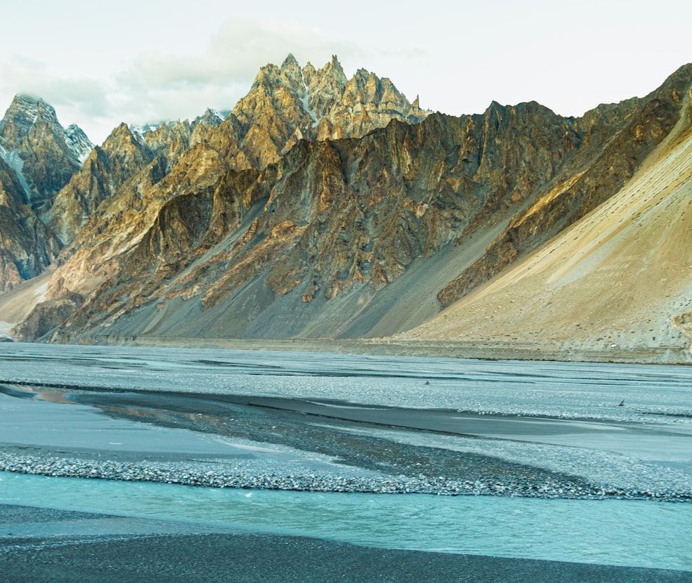 a mountain range with a body of water in the foreground