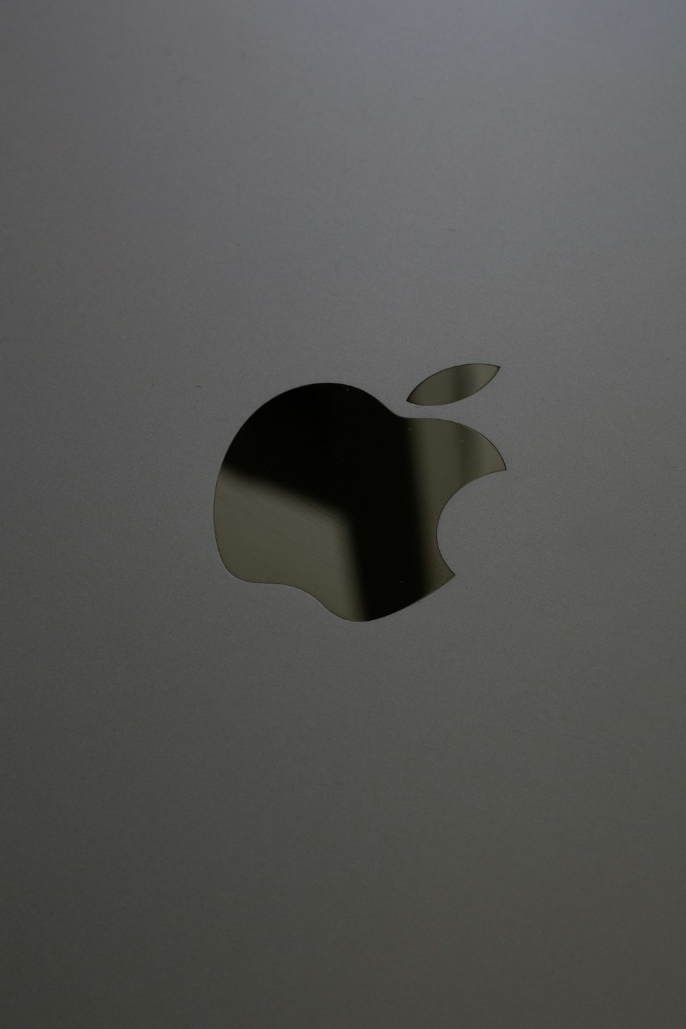 a close up of an apple logo on a laptop