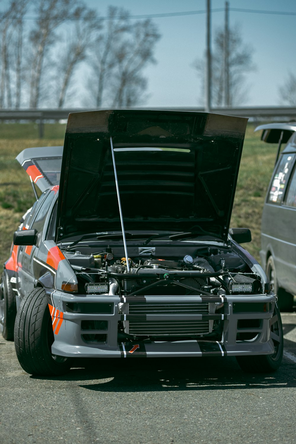 a car with its hood open on the side of the road