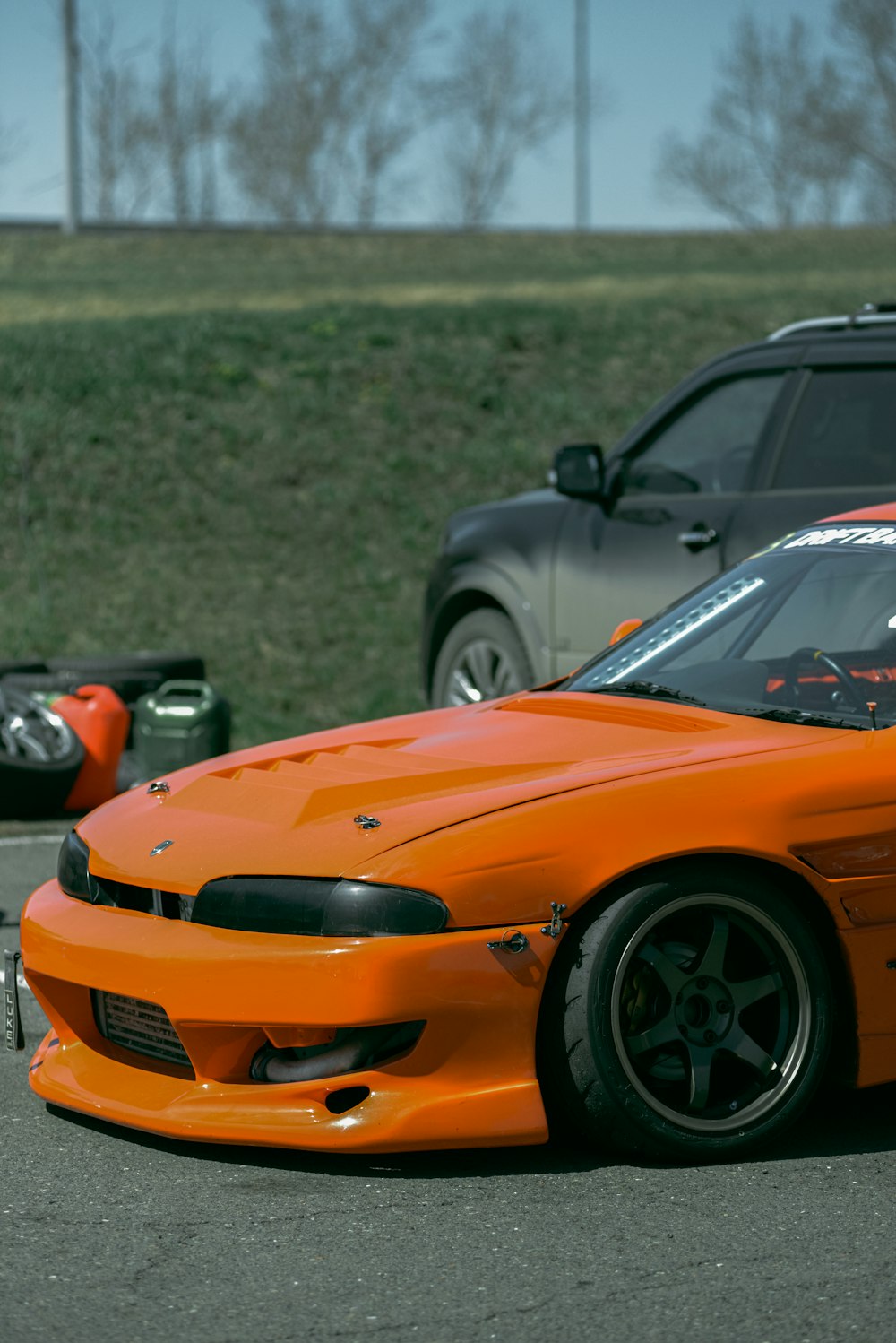 an orange sports car driving down a race track