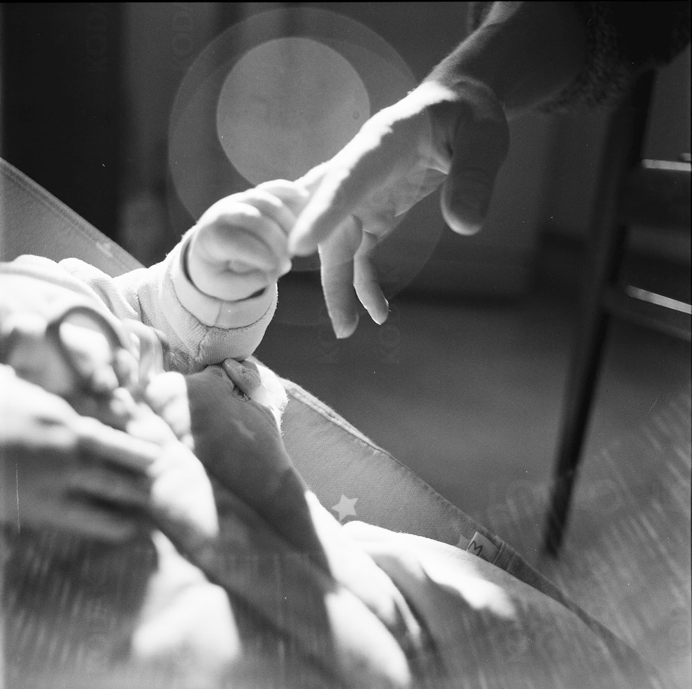 a black and white photo of a person holding a baby