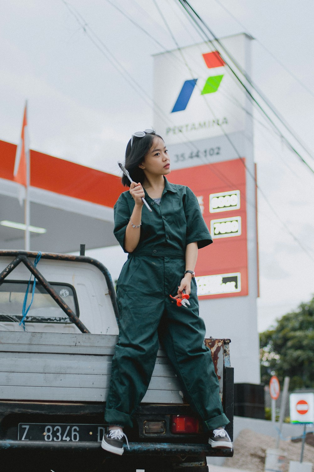 a woman standing on the back of a truck talking on a cell phone