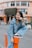 A happy young person wearing trendy casual clothes in a bright urban setting.
