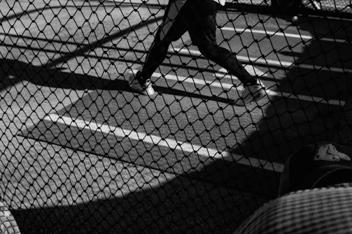 A dynamic shot of a baseball player mid-swing under stadium lights, capturing the intensity and focus of the game.
