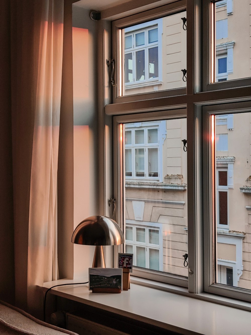 a lamp sitting on a window sill next to a window