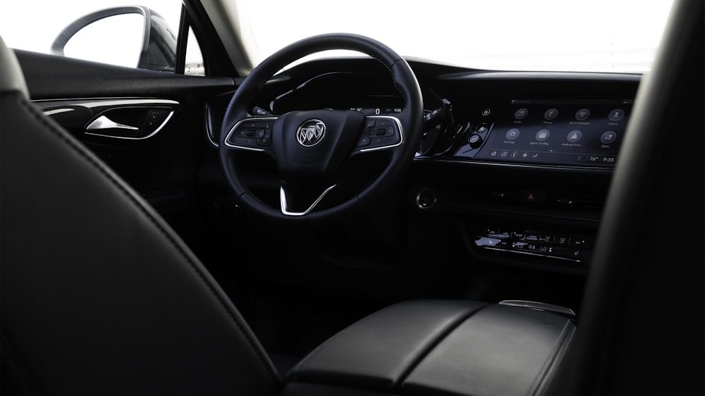 the interior of a car with a steering wheel and dashboard