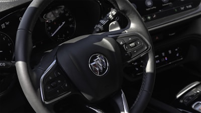 A close-up of a car's steering wheel and dashboard.