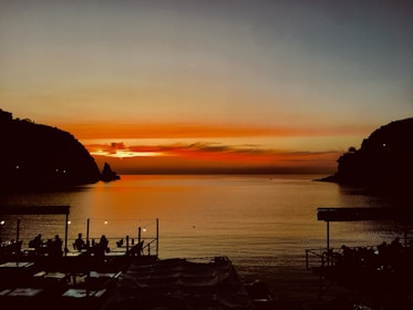 Guests enjoying a sunset meal by the river with calm waters reflecting light.