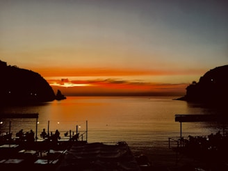 Guests enjoying a sunset meal by the river with calm waters reflecting light.